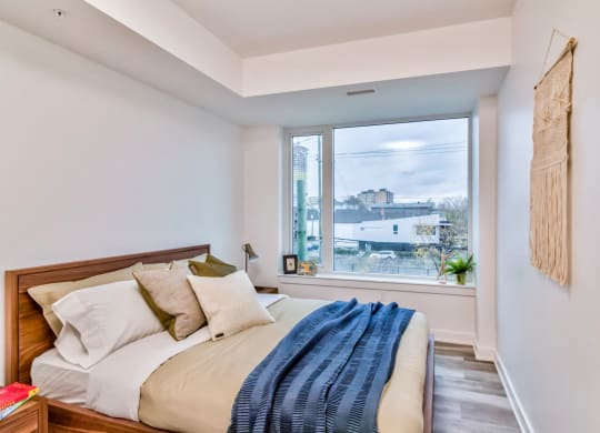 a bedroom with a bed and a large window