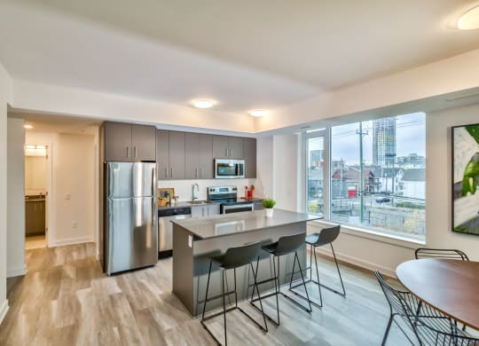 a kitchen with stainless steel appliances and an island with bar stools