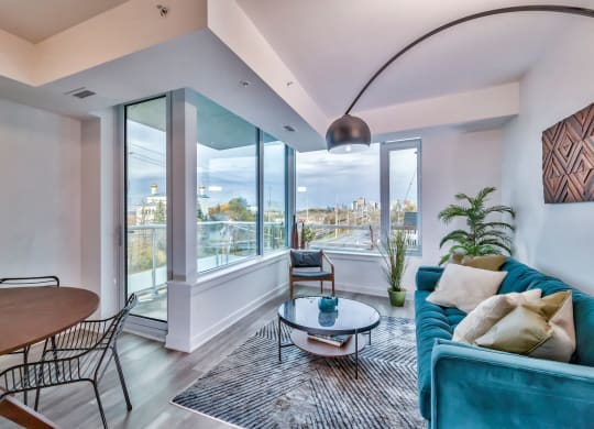 a living room with a blue couch and a view of the city