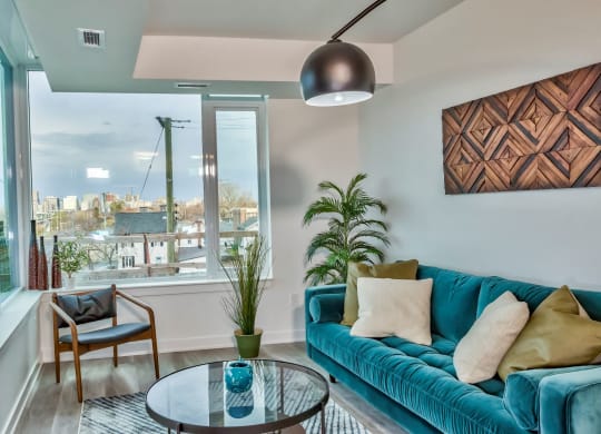 a living room with a blue couch and a large window