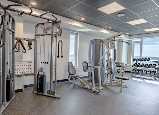 a gym with weights and other equipment in a room with a window