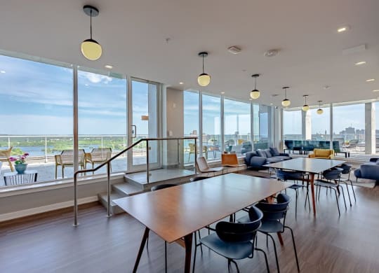 a communal area with tables and chairs and large windows