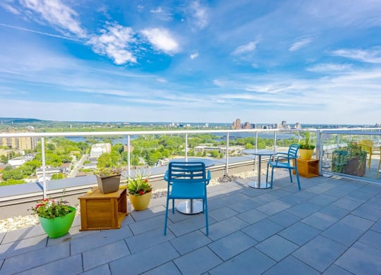 a balcony with blue chairs and a view of the city