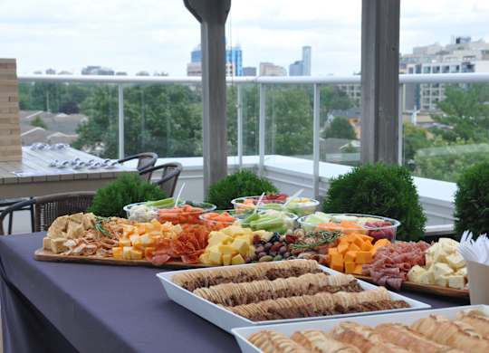 a buffet of food on a table with a city in the background