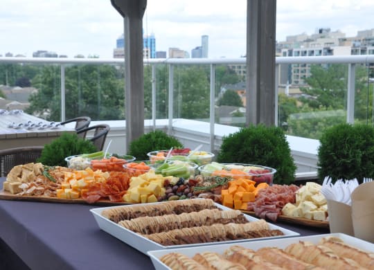 a buffet of food on a table with a city in the background