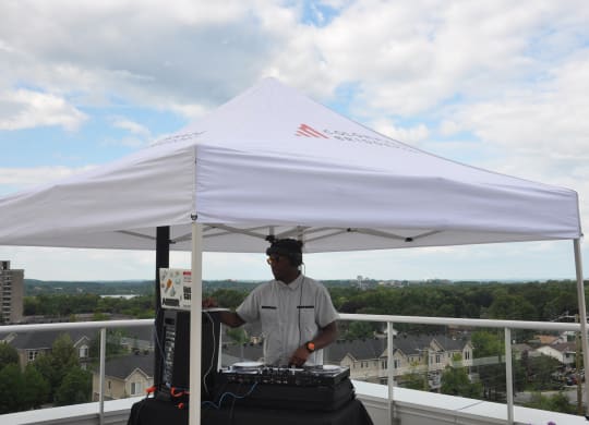 a man standing under a white tent on top of a roof