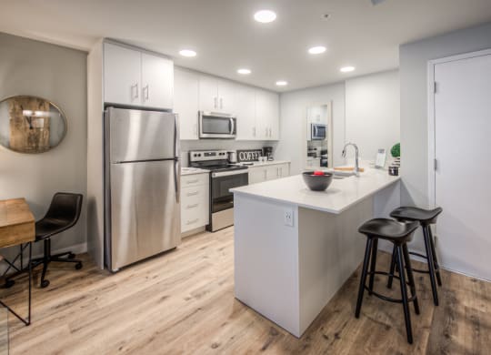 a kitchen with white cabinetry and stainless steel appliances