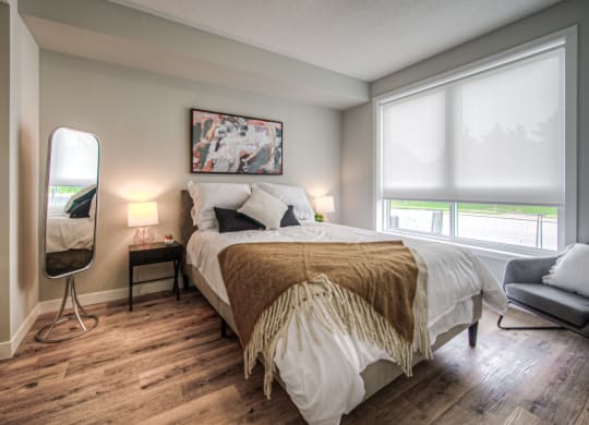 a bedroom with a bed and two windows