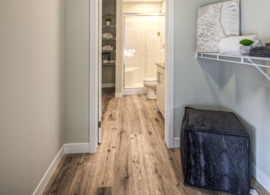 a bedroom with a bed and a stool in a room