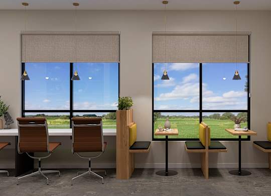 A room with a view of a green field through the windows.