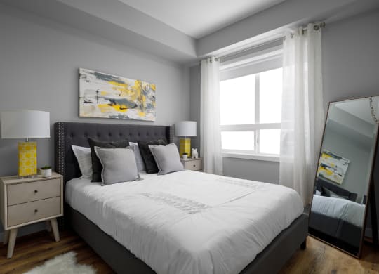 a bedroom with gray walls and a white bed