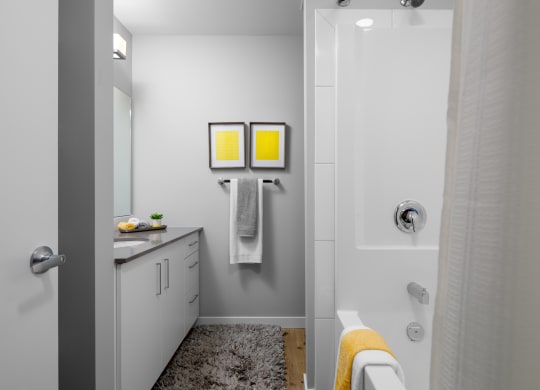 a bathroom with a shower sink and bathtub in a 555 waverly unit