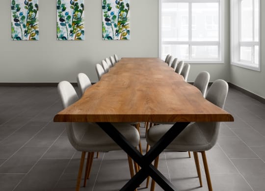 a room with a long wooden table and white chairs