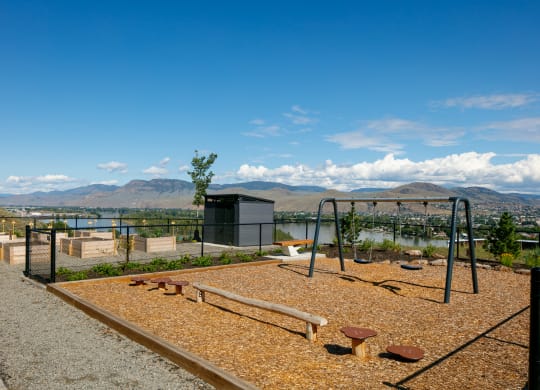 a playground with a view of the water and mountains in the background