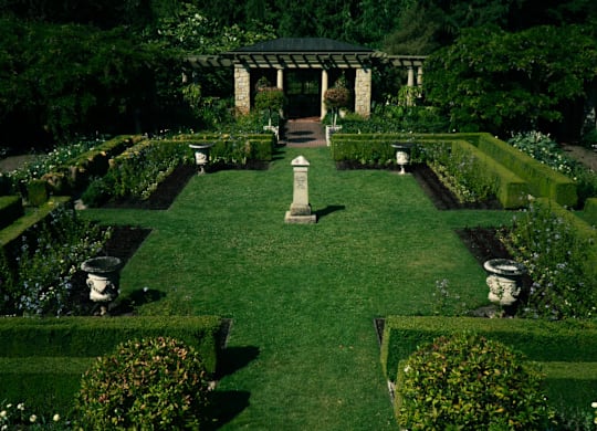 A garden with a statue in the middle of it.