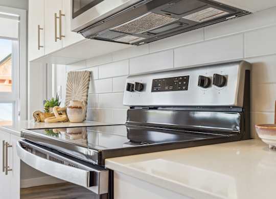 A modern kitchen with a stainless steel oven and white countertops.