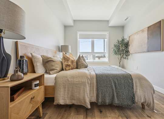 A bedroom with a bed, nightstand, and lamp.