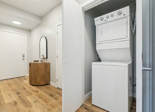 A white washing machine is in a small laundry room.