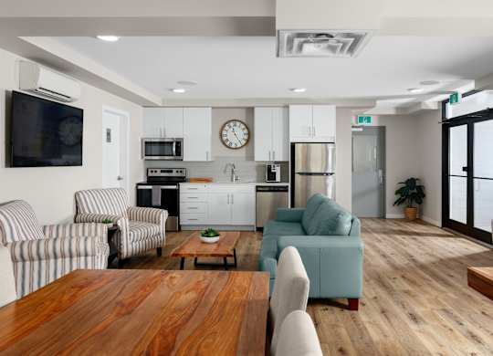 A modern kitchen with a wooden table and striped chairs.