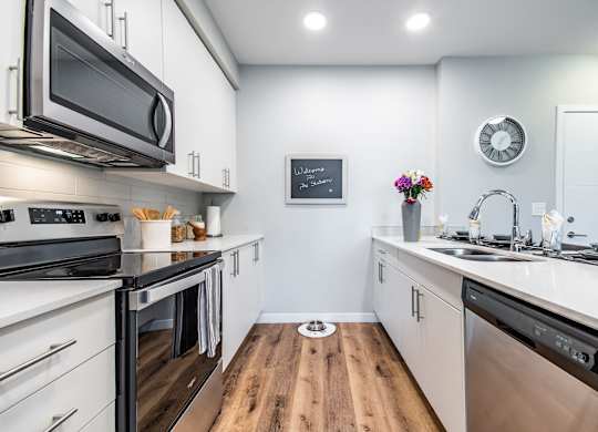 A modern kitchen with stainless steel appliances and white cabinets.