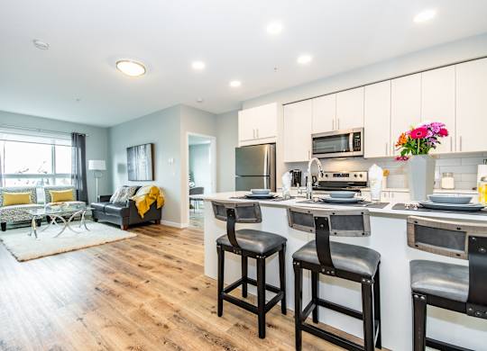 A kitchen with a bar stool in front of it.