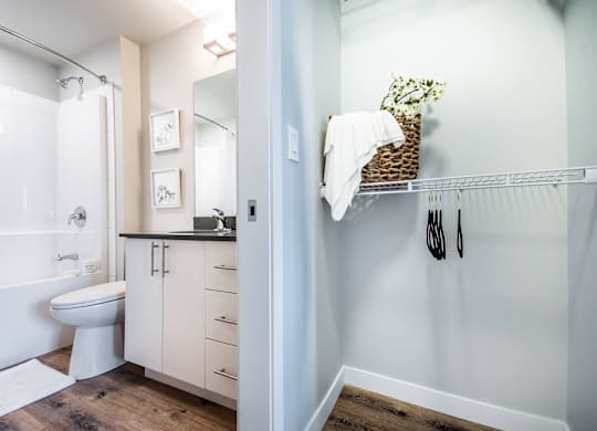 A white bathroom with a toilet, sink, and a mirror.