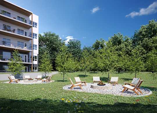 A modern apartment building with a lush green lawn and outdoor furniture.