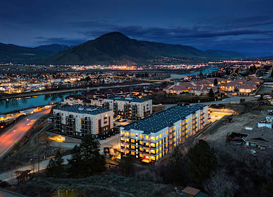 A cityscape at night with a large mountain in the background.