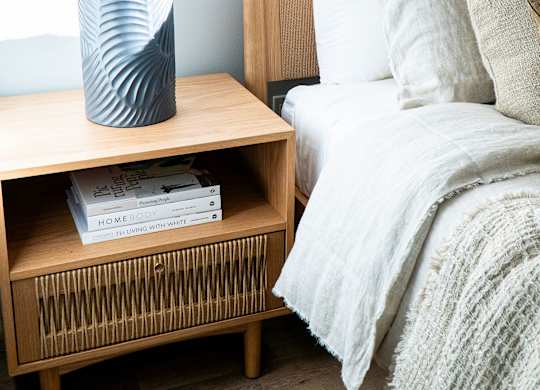 A bedroom with a bed, nightstand, and lamp.