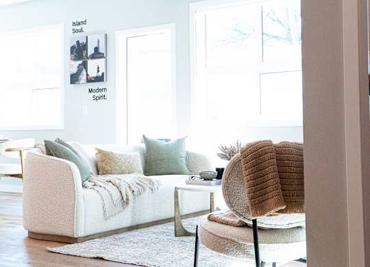 A modern living room with a white couch and a chair.