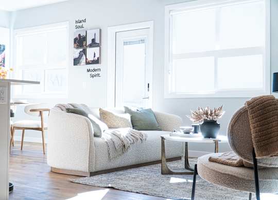 A living room with a white sofa, a chair, and a small table.