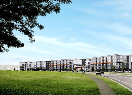 A row of modern apartment buildings with a green lawn in front.