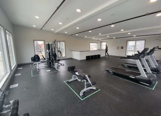 a large fitness room with treadmills and other exercise equipment