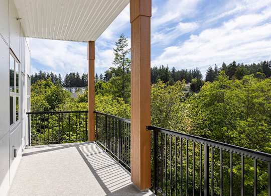 A balcony with a view of a forest.