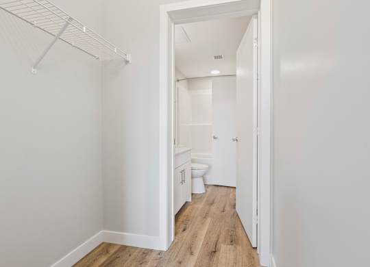A white bathroom with a toilet, sink, and a walk-in shower.