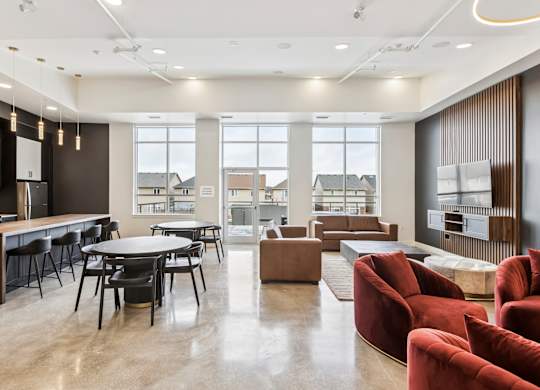 A modern living room with a kitchen area in the background.