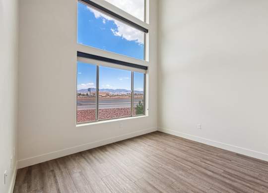 A room with a large window overlooking a road.
