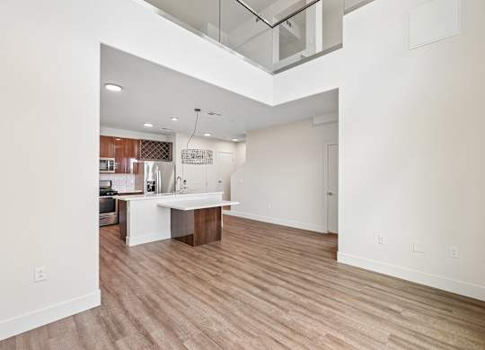 A room with a white kitchen island and wooden flooring.