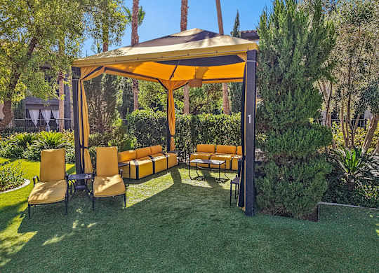 A patio with a yellow canopy and orange chairs.