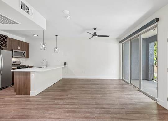 A modern kitchen with wooden floors and white walls.