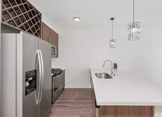 A modern kitchen with a stainless steel refrigerator and a white countertop.