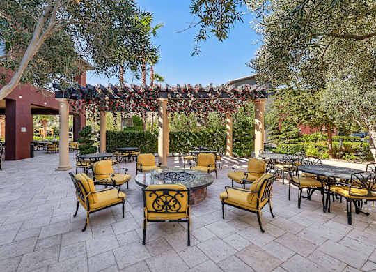A patio with tables and chairs under a pergola.