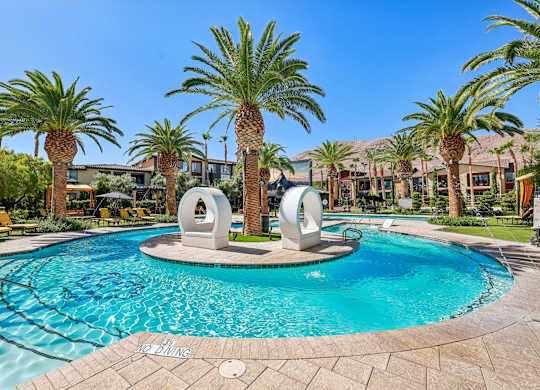 A pool surrounded by palm trees and a clear blue sky.
