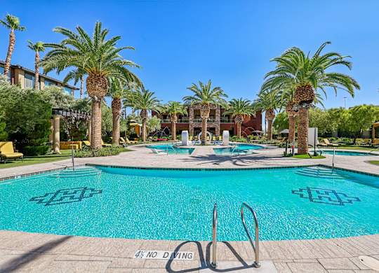 A pool surrounded by palm trees and a no diving sign.