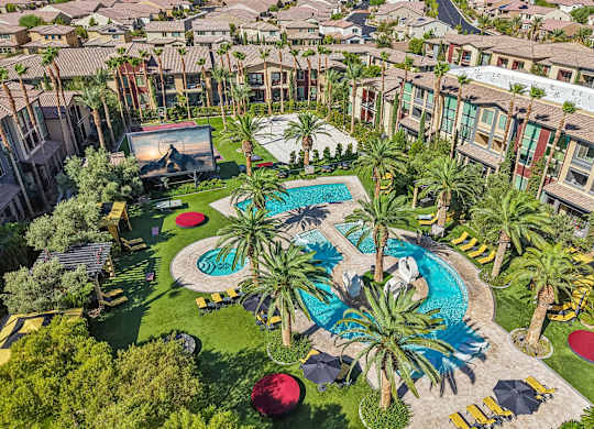 A pool surrounded by palm trees and a red ball.