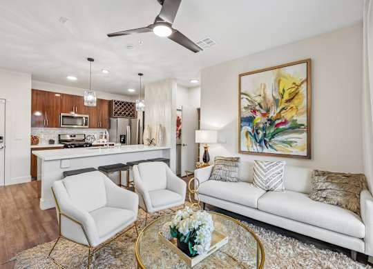 A living room with a white couch, a coffee table, and a painting on the wall.