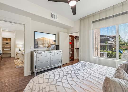A bedroom with a large bed and a television on the wall.