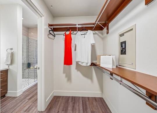 A white and wood hallway with a red dress hanging on the rack.