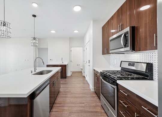 A modern kitchen with dark wood cabinets and white countertops.