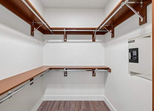 A white room with a wood shelf and a white appliance.